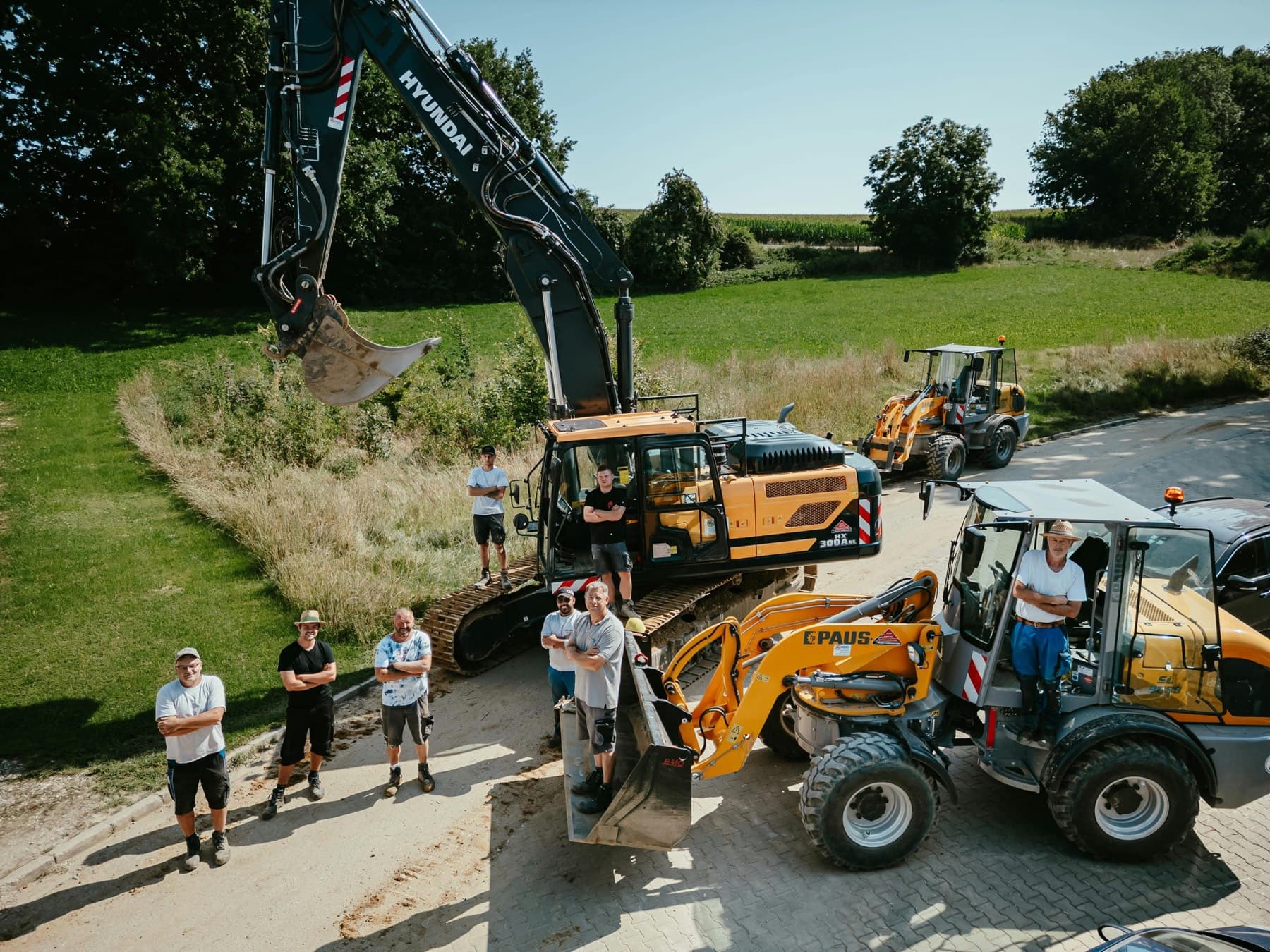 Das Team von Seel Bau steht gemeinsam zwischen mehreren Baumaschinen